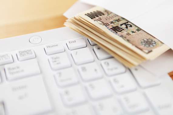 キーボードと封筒に入ったお金