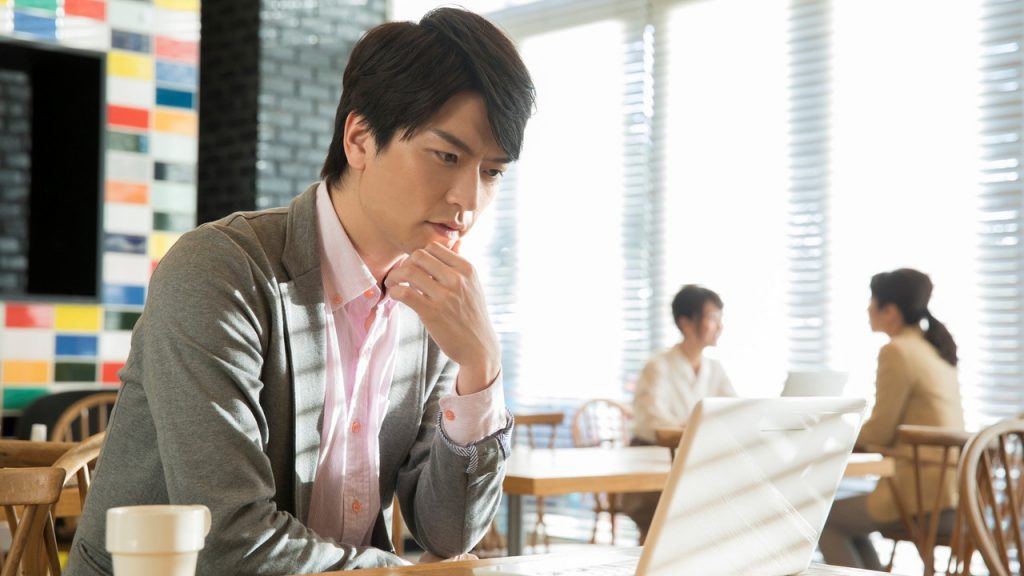 カフェでパソコンを見る男性